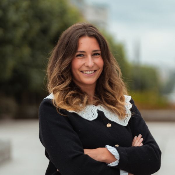 Etudiante souriant face caméra avec les bras croisés