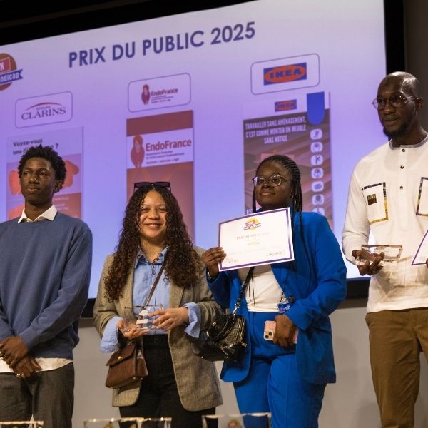 Etudiants gagnants du prix du public Quatre étudiants sur la scène lors d'une remise de prix